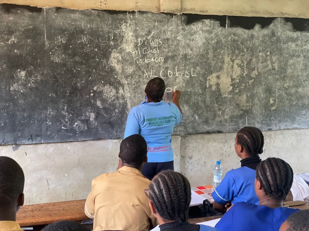 COSUHS staff writing on a chalkboard during a school session