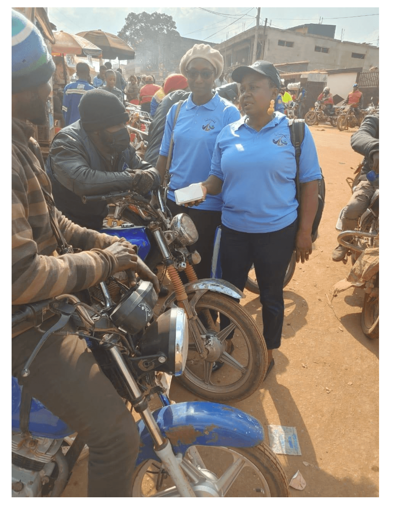 COSUHS team speaking with motorbike riders at a market